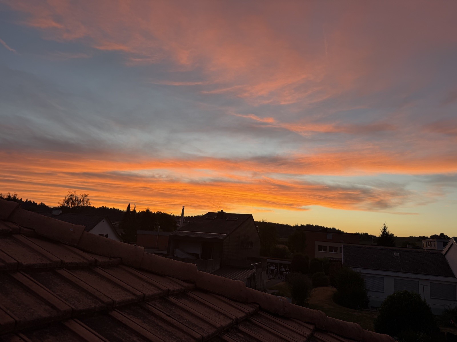 Oranger Abendhimmel über den Dächern von Sumiswald