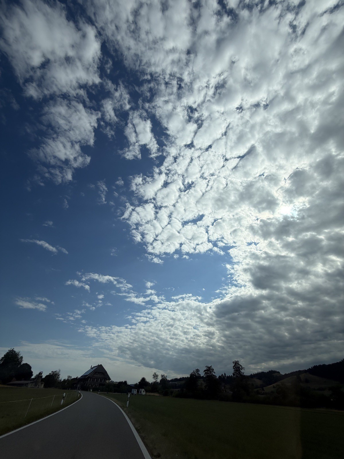 Schäfchenwolken über einer Landstrasse im Emmental